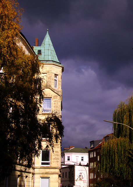 Gebäude mit Spitzdach vor bedrohlichen Regenwolken