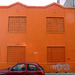Orange building, red car.