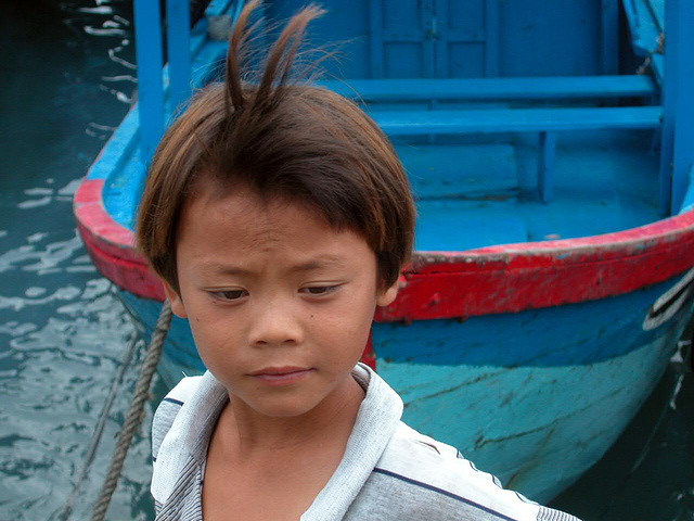 A boy arranges the wharfs for the fishing boats