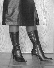 Elsa - Leather high-heeled boots and skirt on tiles floor -  Bottes de cuir à talons hauts et  jupe de circonstance sur plancher de tuiles  -  Avec  / with permission - January 2009. - B & W  /  En noir et blanc.