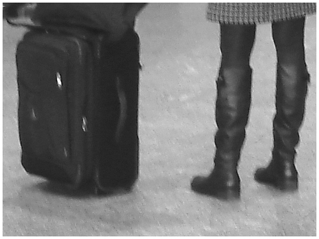 Blond in flat boots and checked skirt /  Blonde en bottes SS et jupe en damiers- Aéroport de Montréal. - Noir et blanc.