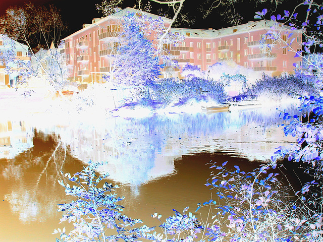 Apartments building and rowboat by the river /  Édifice à appartements avec chaloupe et canards -  Ängelholm / Suède.  23 octobre 2008- Effet de négatif + couleurs ravivées.