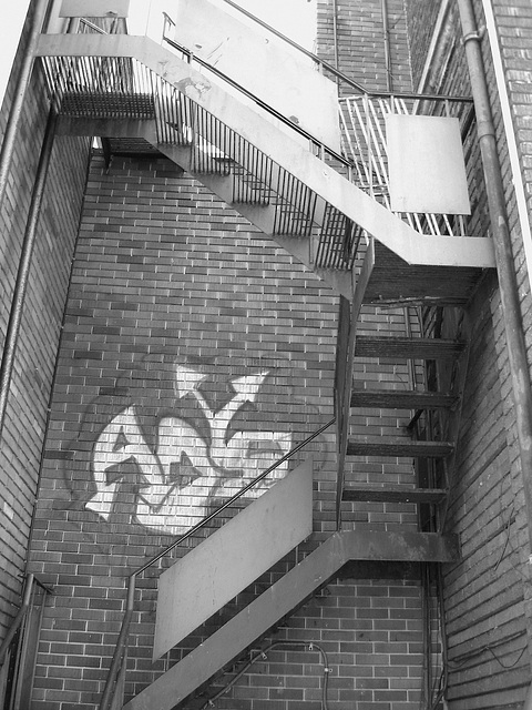 Escaliers de secours et graffiti sur mur de briques /  Fire escape and bricks wall hometown graffiti  / B & W