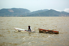 Viro kun du boatoj sur lago - Ein Mann mit zwei Booten auf einem See