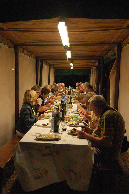 Rondo familia en vespera manĝo en la bela regiono Toskano en Italio.