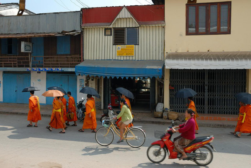 Monks walk along the Chao Siphouphan