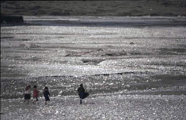 Children walk along the river bed