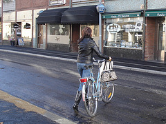 Cycliste en bottes à talons hauts / Walking Swedish biker in jeans & high-heeled boots at her cell phone