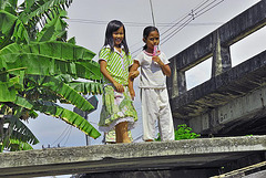 Thai kids on the pier waiting for their longtail boat