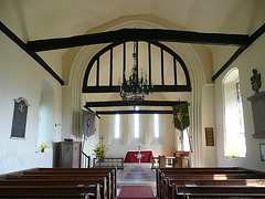 high laver church essex, interior,the outward splay of the chancel arch was arrested in 1963 but still shows despite the strength of the tympanum in the head of the  c15 arch. locke's tomb is just visible on the right wall.