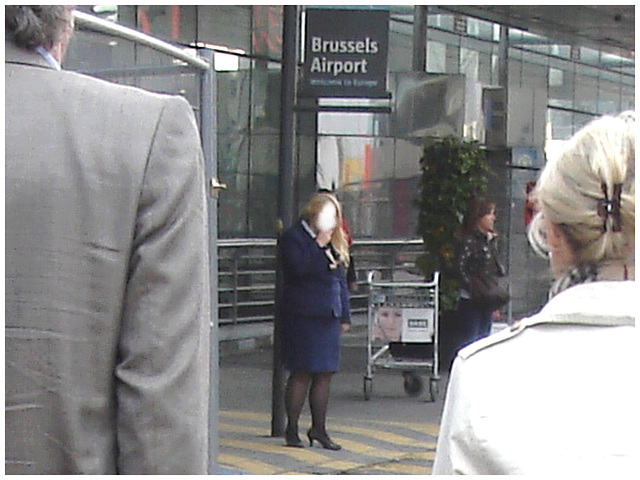 Distant blurry chubby blond flight attendant smoker in high heels  /  Hôtesse de l'air dodue en pause-cigarette - Brussels airport -19-10-2008 - Anonyme
