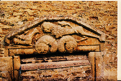 ampney st.mary glos. c.1120 A lion strides across two beasts' heads towards a griffin on this odd shaped c12  tympanum