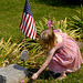 Little Emma, her father active military, places flowers