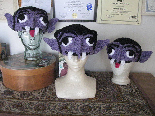 Three crocheted Count von Count hats