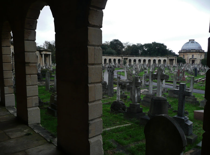 brompton cemetery, earls court,  london,designed in 1838 by benjamin baud, the arcades flanking the central path lead to a circus of similar arcades, with a circular chapel as the point de vue. there are catacombs below some of the arcades.