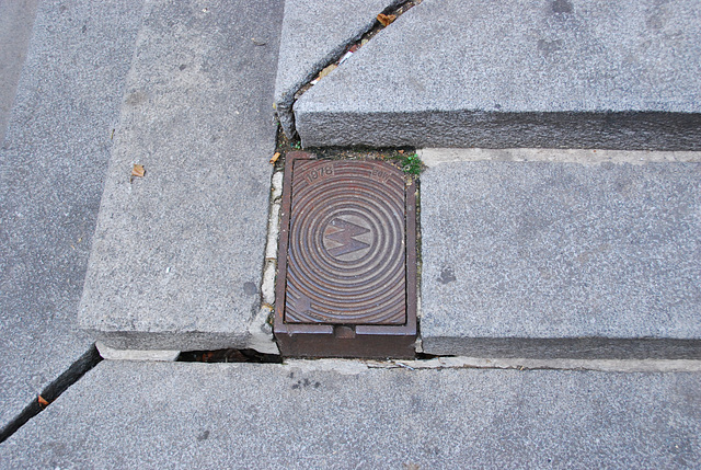 Viennese street covers: Water mains cover nicely fitted into a staircase