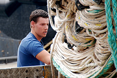 Young man collecting nets from the shipping vessels in the Scheveningen harbour