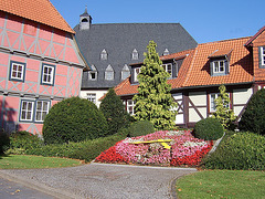 Schiefes Haus mit Blumenuhr