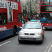 Police car squeezing between two busses on Oxford Street