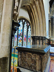 wimborne minster, dorset,arch between the raised chancel and the north chancel aisle chapel, built c.1250, reusing carved figures of c.1200.  the  purbeck tomb chest is that of the marchioness of exeter, + 1557, gertrude, wife of henry courtenay, earl of