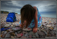 Painting pebbles on the beach.