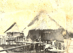 Fijian thatched huts, built over the water, c. 1945.