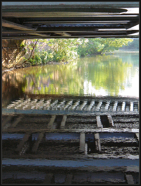 reflections beneath a bridge