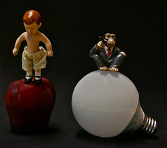 Portrait of a Young Boy Balancing on an Apple Next to a Chimpanzee Balancing on a Light Bulb
