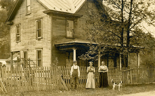 Boy, Women, and Dog in Front of a House