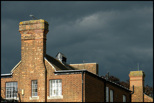 red brick chimneys in a stormy sky