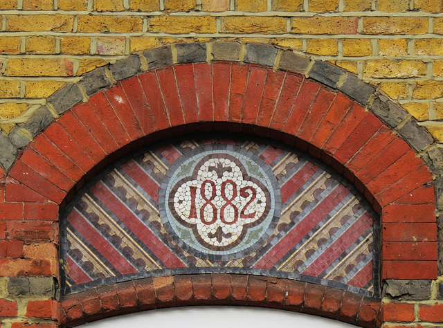 66 doric way,somers town, euston, london,1882 mosaic tilework tympanum on the  first floor of a row of shops.