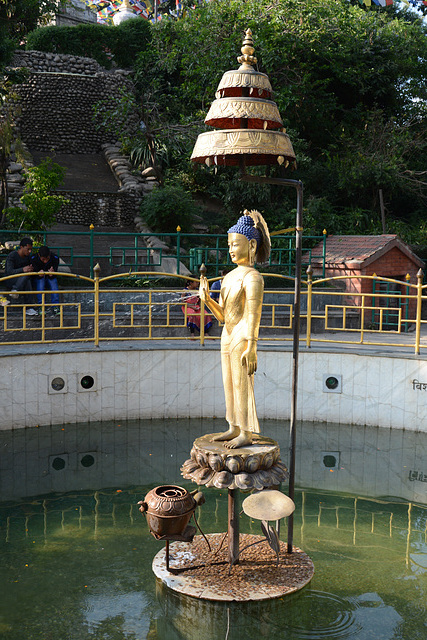 Kathmandu, Swayambhunath, A Bronze Statue of Buddha at the Centre of the Circular Pond