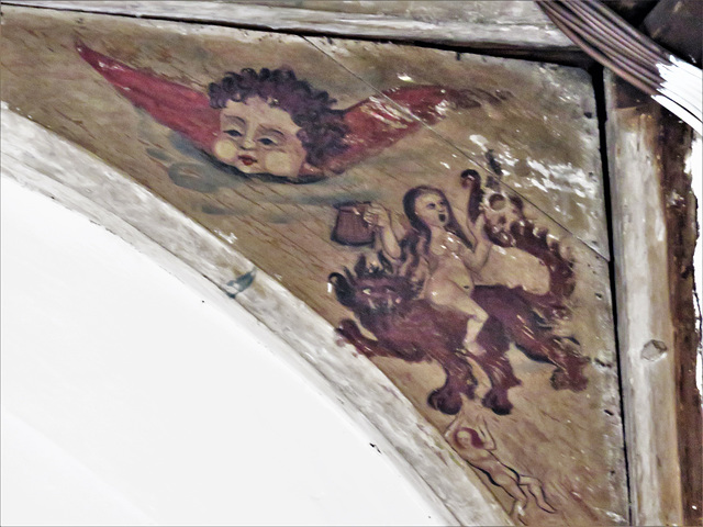 barking church, essex, painting on spandrel over chancel arch. restored c17 cherub, but what to make of figures below? perhaps a dishonest alewife and devil with falling soul below