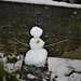 Little snowman sitting on bench