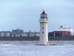 Perch rock lighthouse with the River Mersey ..Liverpool docks in the background.