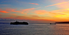 Cabo Menor, o Isla de Mouro.Mercante entrando en la bahia al amanecer.