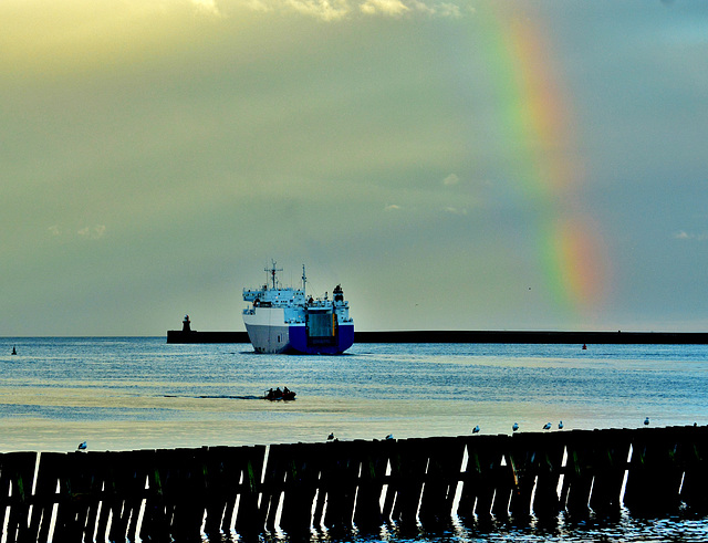 Ship sailing past the rainbow