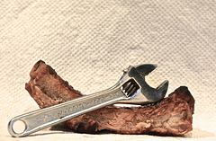 A Cresent Wrench Resting on a Bar-B-Qued Rib