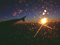 Eiskristalle am Flugzeugfenster mit Sonnenuntergang
