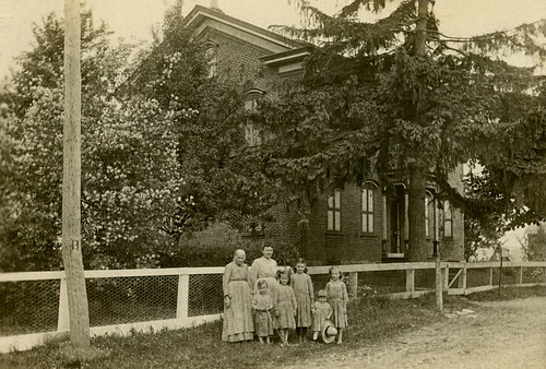 Women and Kids in Front of a House