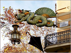 Barcellona : Pla de la Boqueria - Un drago sostiene il lampione sopra un antico negozio di 'solo ombrelli'