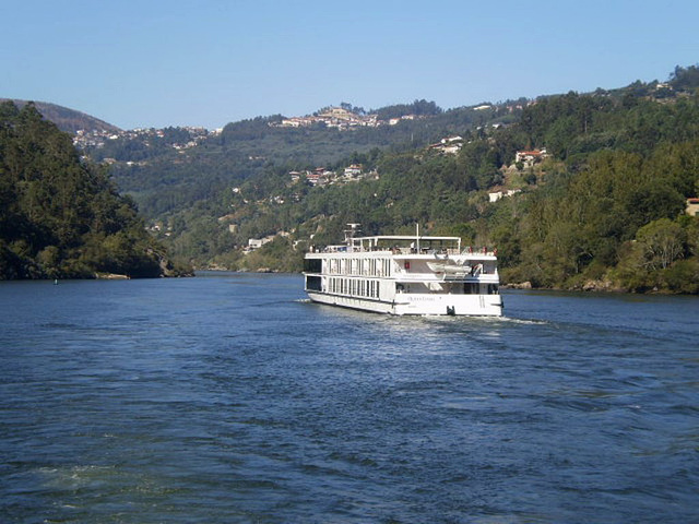 Cruise boat with cabins going downstream.