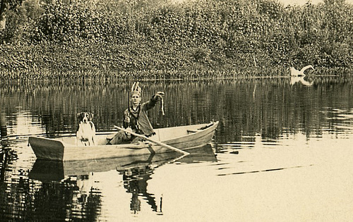 Playing Indian and Fishing with a Dog in a Rowboat (Cropped)