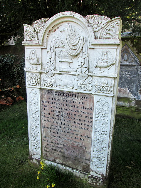 Grave of 18th century Cumberland huntsman John Peel, complete with carved hunting horns and gun dog.