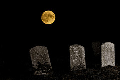 The full moon rises over three gravestones!