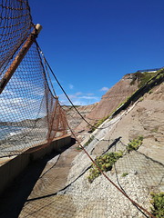 Is it the net that protects the cliff, or the cliff that protects the net?