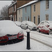 snowy cars in an English street