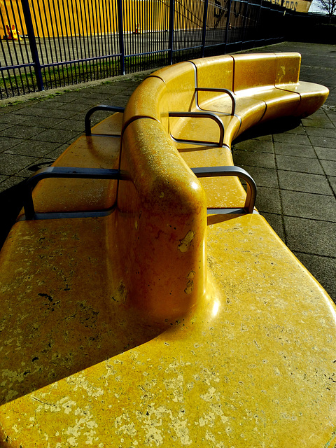 Yellow Tanker Docks Beside Matching Benches