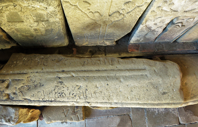bakewell  church, derbs (91)coped coffin lid cross slab with stepped cross and rough  lettering, perhaps c12 or earlier