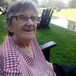Grandma im Park auf Sonnenstuhl am Wasser
